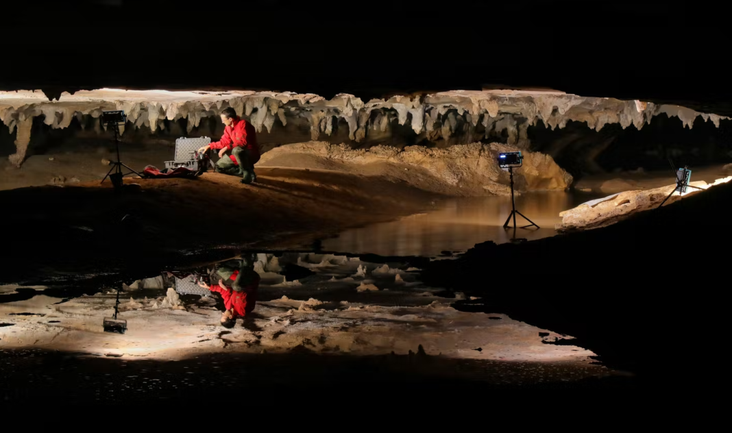 Photo by Alan Cressler shows Stephen Alvarez Photographing ancien drawings in a cave in Alabama.